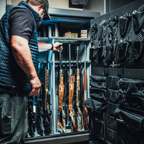 Man opening safe full of rifles